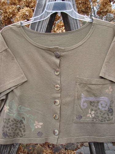 1994 Song Top Garden Bark Size 1: A close-up of a shirt with a wide, shallow neckline, vintage buttons, and a painted breast pocket.