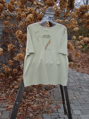 2001 Short Sleeved Tee Glider Plane Kelp Size 1: A t-shirt with a glider plane theme paint, drop shoulders, and a ribbed neckline.