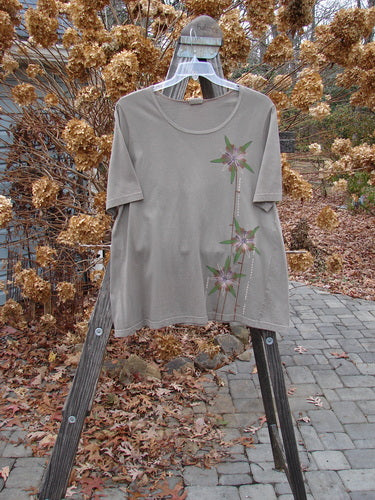 A Barclay Short Sleeved A Line Top in Storm Grey, featuring a flower design, on a swinger.