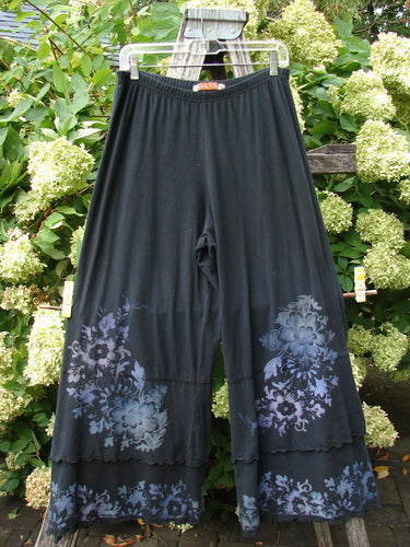Barclay Cotton Lycra Crop Double Ruffle Pantaloon Pant Floral Black Size 1 in black cotton-lycra, with a wide elastic waist and flowing cropped legs. Floral motifs in muted blue and lavender gather near the hems, where double ruffle-edged panels add a layered finish.
