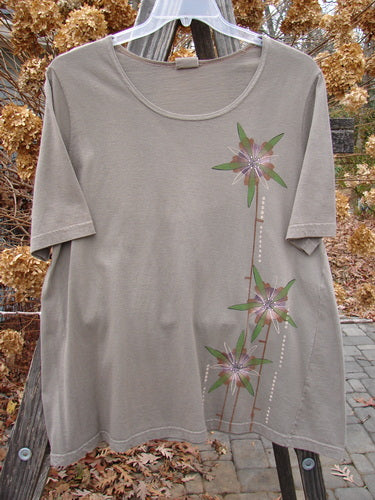 Barclay Short Sleeved A Line Top Lolly Daisy Storm Grey Size 0: A t-shirt with a flower design, featuring a tall stem blossom theme paint and a billowy bottom flare.