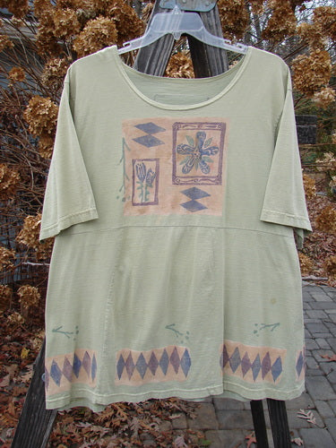 Image alt text: "1993 3 Square Dress Trinket Diamond Kelp OSFA: A green shirt with a pattern on it, featuring a slight empire waist seam, six sectional panels, and a rounded neckline."