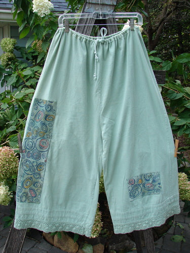 1992 PMU Patched Pantaloon Continuous Spin Cucumber OSFA hanging on a clothesline, showcasing a full drawcord waistline, wide lowers, antique lace accents, and patches from the 1992 collection.