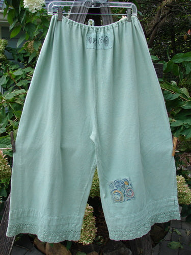 1992 PMU Patched Pantaloon Continuous Spin Cucumber OSFA hanging on a clothesline, showcasing a full drawcord waistline, wide swingy lowers, and antique lace accents.