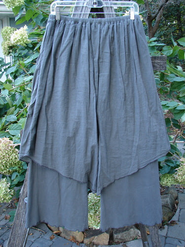 Barclay Cotton Lycra Batiste V Pocket Pant Crop Pant in Stone Grey, featuring a layered skirt-like overpiece with raw seams and side pocket, showcasing a unique, billowy design from Bluefishfinder.com.