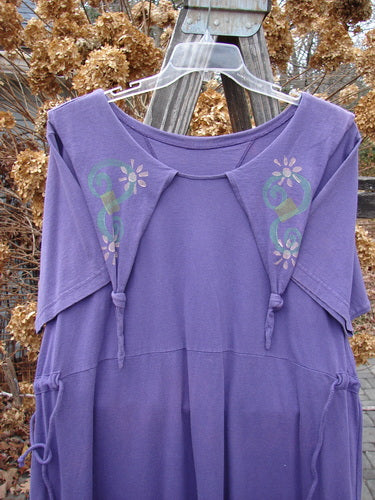 1994 Elfin Dress in Purple Nuit with a design on it. Rare and playful piece from the Transitional Collection. A-line shape, empire waist, and rear tie tunnel for adjusting waistline.