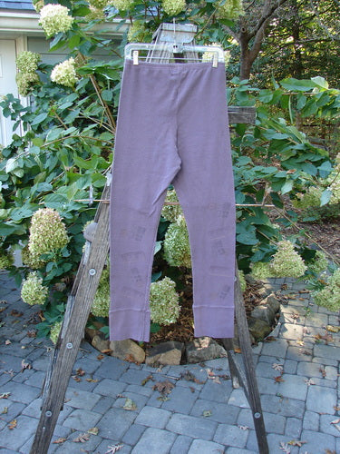 2000 Thermal Layering Lu Pant Soft Geos Eggplant Size 1 hanging on a clothesline, showcasing its ribbed lowers and pocketless design, with a professionally replaced elastic waistband, perfect for vintage enthusiasts.