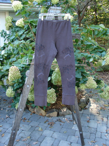 2000 Thermal Layering Lu Pant Soft Geo Brum Size 1 displayed on a wooden ladder, showcasing pocketless hips and ribbed lowers, with a replaced elastic waistband and longer inseam.