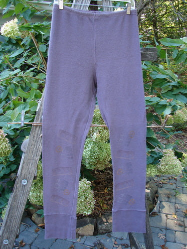 2000 Thermal Layering Lu Pant in Soft Geo Eggplant, displayed on a wooden rack, showcasing its professionally replaced elastic waistband and ribbed lowers, highlighting its vintage appeal from Bluefishfinder.com.