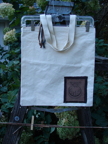 1998 PMU Patched Cotton Canvas Tote Bag Oak Leaf Natural One Size displayed hanging, showcasing its sturdy organic cotton canvas with unique oak leaf patches and tightly woven shoulder straps, epitomizing sustainable vintage creativity.