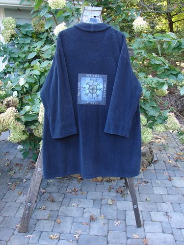 1999 Patched Chenille Angle Pocket Jacket with oversized vintage button closure, drop shoulders, and diagonal floppy pockets. Displayed on a stand, highlighting its unique chenille fabric and vintage design.