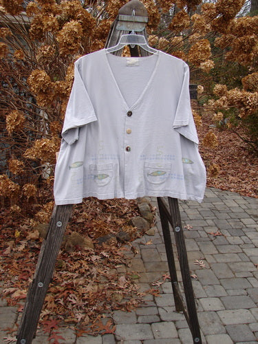 1999 Tiny Pocket Top Fish Water Size 2: A swingy white shirt on a clothes rack, featuring a cropped A-line shape, oval bottom pockets, and a ceramic button.