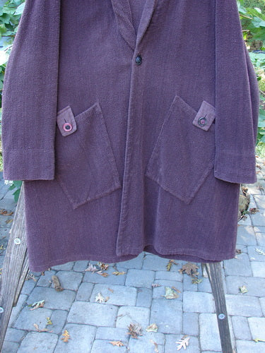 1999 Patched Chenille Angle Pocket Jacket, featuring oversized vintage buttons and diagonal pockets, displayed on a rack. Known for its unique patchwork and vintage style, a signature piece from BlueFishFinder.com.