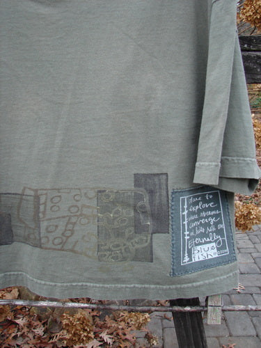 A close-up of a green City Side Crop Tee Top Block Park Size 0 shirt with a label and painting accents.