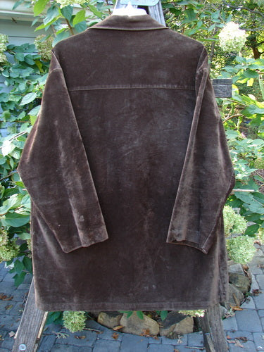 1999 Limited Edition Shed Jacket Unpainted Deepest Brown Size 1 displayed outdoors on a wooden swing, highlighting its plush fabric, angular front pockets, and rubberized buttons, embodying vintage charm from Bluefishfinder.com.