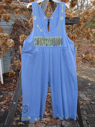 Image alt text: "1993 Railroad Overall Jumper Abstract Tool Periwinkle Size 1: Blue overalls with logo on wooden fence, close-up of pants, yellow and black sign, close-up of wood plank"