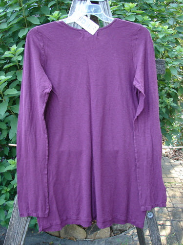 Barclay NWT Slub Cotton Hemp Long Sleeved Simple Tee Crystal Tyrian Berry Size 1 features a rounded slightly dipped neckline and cozy full-length sleeves, showcased on a clothes rack.
