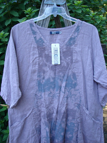 Barclay NWT Linen Posey Tunic Dress in Orchid Field Sea Fog size 0, featuring an oval neckline, flowy figure-eight shape, almost three-quarter sleeves, and two front pockets displayed on a hanger.