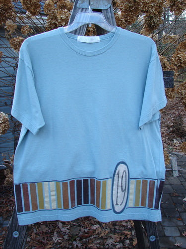 1998 Short Sleeved Tee Number 19 Pool Size 1: A blue t-shirt with a number on it from the Summer Collection of 1998. Made from mid-weight organic cotton, it features a board games border theme paint, drop shoulders, and a ribbed neckline. Bust 48, waist 48, hips 48, length 27 inches.