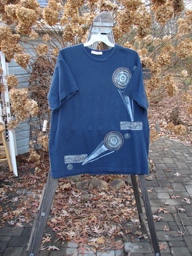 1998 Short Sleeved Tee Arrow Game Crew Blue Size 2: A blue shirt with a design on it. Perfect condition, made from organic cotton. Features drop shoulders, ribbed neckline, and Blue Fish patch.