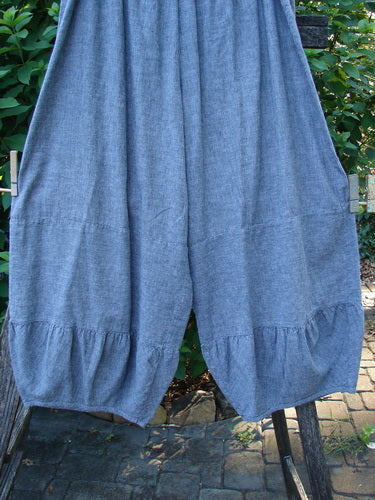 Barclay Hemp Cotton Meadow Pant in Indigo Stripe, Size 1, with a full elastic waist and gathered horizontal panels. Displayed outdoors on a clothesline, showcasing its lightweight, cropped design perfect for spring or summer.