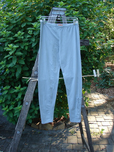 Barclay Cotton Lycra Side Gather Legging Unpainted Grey Grass Size 1 displayed hanging on a clothesline, showcasing its soft, tapering design with lower exterior drawcords and a full elastic waistband.