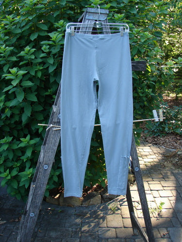 Barclay Cotton Lycra Side Gather Legging Unpainted Grey Grass Size 1 displayed elegantly on a wooden ladder, showcasing its full thinner elastic waistband and tapering lowers with exterior drawcords.
