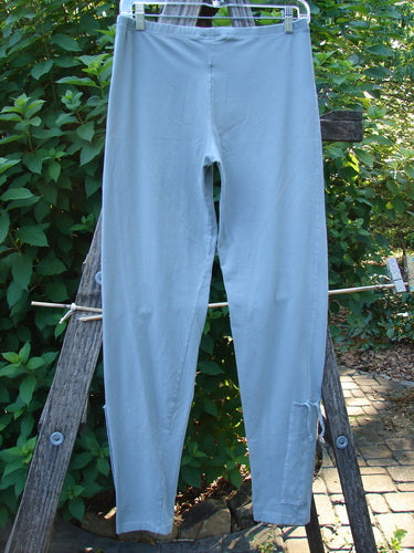 Barclay Cotton Lycra Side Gather Legging Unpainted Grey Grass Size 1 displayed on a wooden ladder, showcasing its tapering lower design and elastic waistband, ideal for mixing and matching.