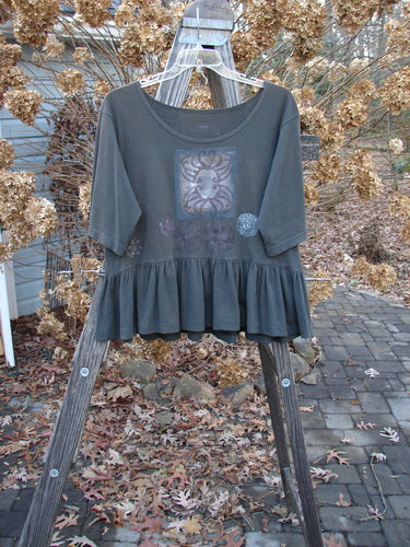 1992 Holiday Short Sleeved Peplum Top: A grey shirt with a picture on it, featuring a thinner ribbed neckline, drop shoulders, and a wonderful peplum lower. Perfect condition.