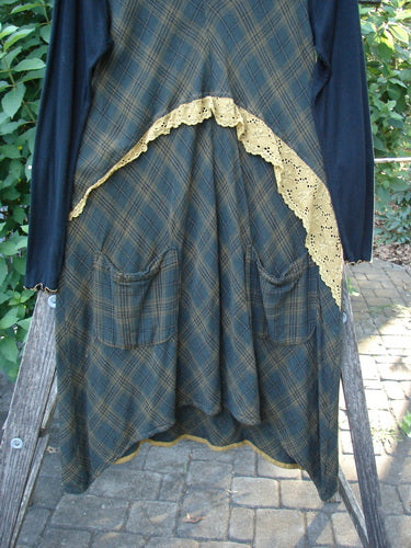 Barclay Rayon Linen Ruffle Pocket Dress in brown plaid, featuring a hi-low hemline, narrow ribbed sleeves, contrasting gold piping, lace accents, and a lightweight hoodie, embodying BlueFishFinder's creative vintage style.