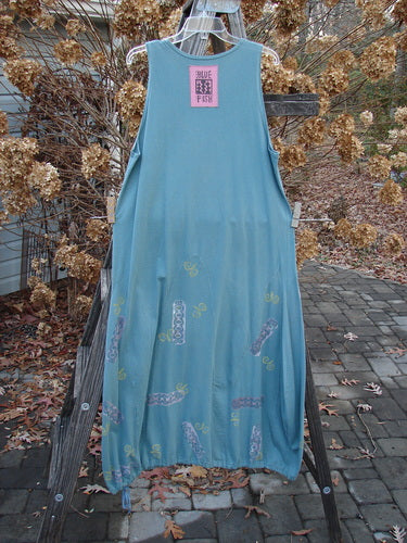 1993 Journey Jumper Vase and Heart Ocean Size 1: Blue dress on a clothes rack with white design, featuring lower vertical arches, a belled shape, a scooped neckline, and deeper arm openings.