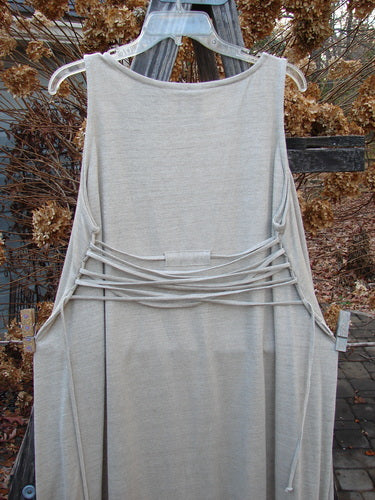 1998 Linen Knit Wrap Dress Unpainted Natural Size 2: A dress on a clothesline, made from flowing linen knit, with a rounded neckline and smaller arm openings.
