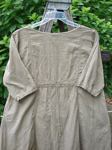 Barclay Batiste Bliss Dress Fallen Petal Stonetail Size 0 displayed on a hanger, featuring a softly rounded neckline, short sleeves, full center art section, exterior flop pockets, and drawcord back.