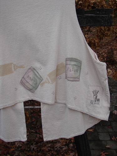 Image alt text: 1999 The Tab Vest Baker Tea Dye Size 2: White towel with a picture of a flour container and a bottle, featuring a baking theme paint.