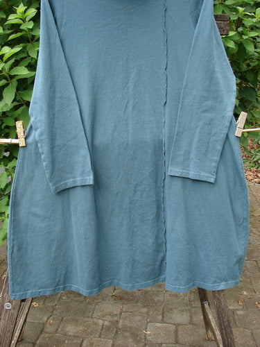 Barclay NWT Eco Cotton Cowl Pocket Tunic Star Moon Hypnea Teal Size 0, showcased on a clothesline, features a unique cowl pocket design, highlighting the vintage-inspired creativity of BlueFishFinder.com.