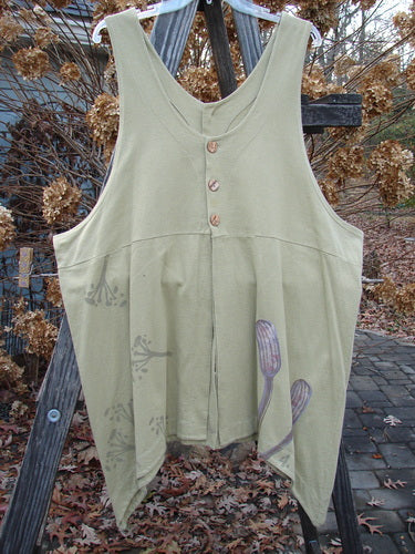 1998 Botanicals Aster Vest Long Stem Seed Size 2: A green shirt with buttons on it. Close-up of a dress with unique front and rear vents. A wood plank and a curtain in the background.