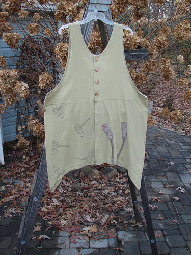 1998 Botanicals Aster Vest Long Stem Seed Size 2: A vest on a wooden easel. Features a deep rounded neckline, empire waist seam, unique vents, and wavy shell-like buttons. Perfect layering piece from the Spring Collection of Blue Fish Clothing.