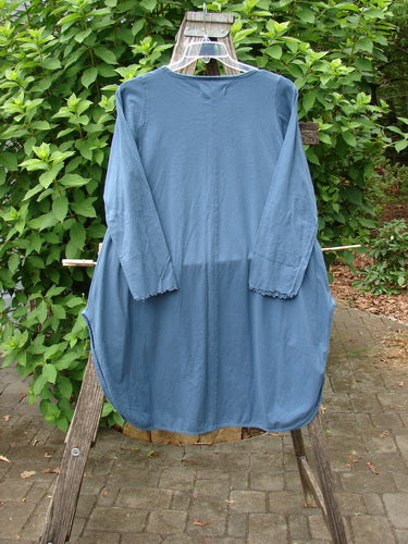 Barclay NWT Natalia Round Bottom Tunic City Floral Echo Blue Size 0, displayed on a wooden rack, showcasing its unique sleeve design and flowing round bottom, embodying Bluefishfinder.com's vintage elegance.