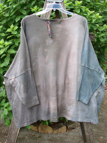 Barclay NWT Patched Supima Taos Mountain Tunic Belief Spirit Magic Peace Grey OSFA, displayed on a clothes rack, showcases detailed patchwork and a relaxed, flowing design, embodying creative freedom and individuality.