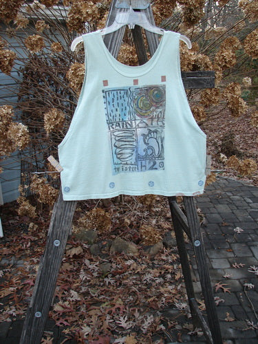 1992 Workout Tank Elements Cucumber OSFA: A white tank top on a wooden easel, featuring a graphic design. Perfect for hot summer days.