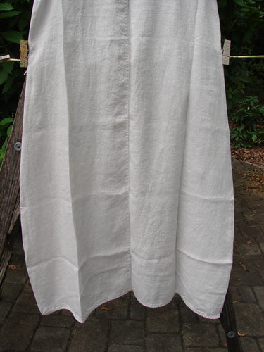 Barclay NWT Linen Sundress Spin Floral Garden Natural Fog Size 0 hangs gracefully on a clothesline, showcasing its elegant textile design, perfect for expressing individuality through vintage Blue Fish Clothing style.