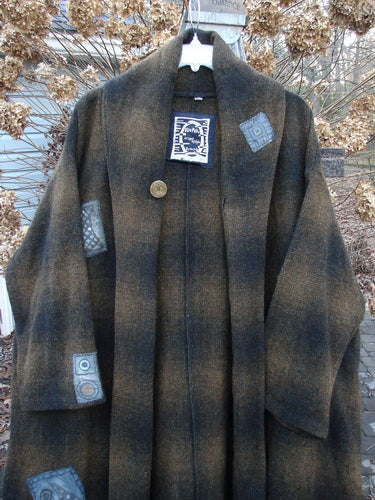 1995 Patched Theater Coat Music Man Cottage Brown Plaid OSFA: A vintage coat with an oversized button closure, A-line shape, and cozy collar. Features deep side pockets, foldable cuffs, and unique patches. Perfect for winter.
