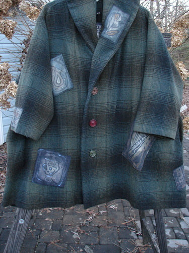 1995 Patched Hooded Autumn Jacket in Cottage Green Plaid on a coat rack. Vintage buttons, oversized shape, cozy double-lined hood, deep pockets, and unique patches. A true winter treasure!
