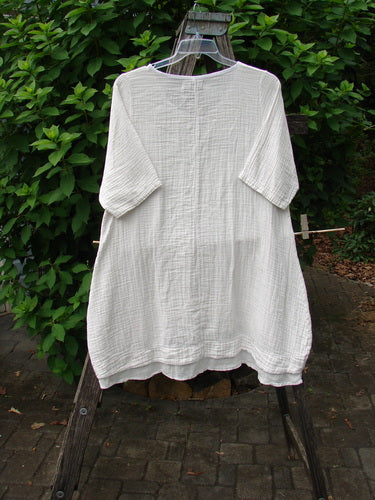 Barclay NWT Gauze Hi Low Batiste Flutter Dress Unpainted Jasmine Dew Size 0 displayed on a chair, showcasing its elegant flutter design and vintage-inspired style, reflecting BlueFishFinder's unique fashion ethos.