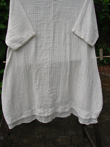 Barclay NWT Gauze Hi Low Batiste Flutter Dress Unpainted Jasmine Dew Size 0 displayed elegantly on a clothes rack, capturing the vintage charm and creative freedom characterizing Bluefishfinder.com’s unique offerings.