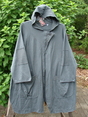 Barclay NWT Reprocessed Patched Hooded Button Jacket Unpainted Grey Storm Size 0 displayed on a hanger, showcasing its unique patchwork design and button details, embodying vintage Blue Fish Clothing's creative expression.