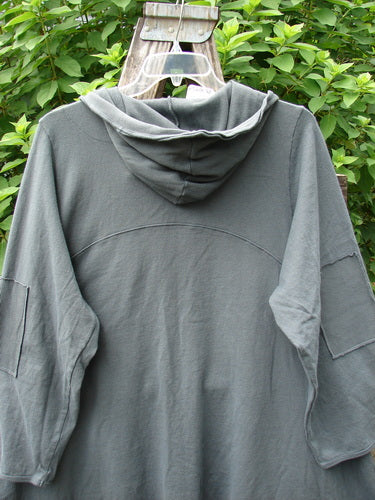 Barclay NWT Reprocessed Patched Hooded Button Jacket, displayed on a swinger, showcases its unique patchwork design. Perfect for expressing individuality, this unpainted grey storm jacket embodies BlueFishFinder's vintage aesthetic.