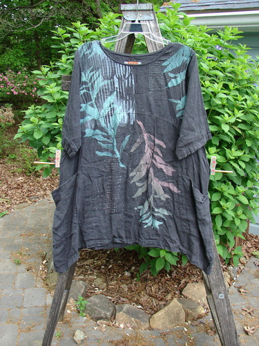 Barclay Linen Two Pocket Urchin Dress Falling Branch Black Size 1 features a rounded neckline, sectional panels, curved empire waist, asymmetric sides, three-quarter sleeves, and double front wrap pockets in medium-weight linen.