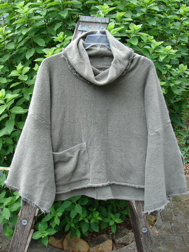 Barclay Sherpa Patched Wide Cowl Pocket Pullover in Unpainted Sea Moss, displayed on a swinger, showcasing its cozy wide cowl and practical pockets, embodying Bluefishfinder.com's vintage, expressive style.