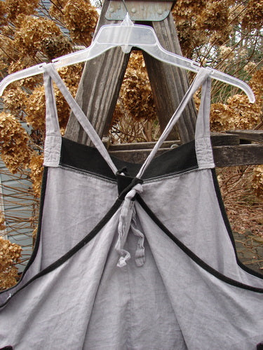 Barclay PMU Patched Linen Contrast Apron Jumper, a grey dress on a swinger. Versatile shoulder straps, botanicals patch, drop pockets, deep arm openings, contrasting colorway, banded hemline, and A-line drape. Size 1.